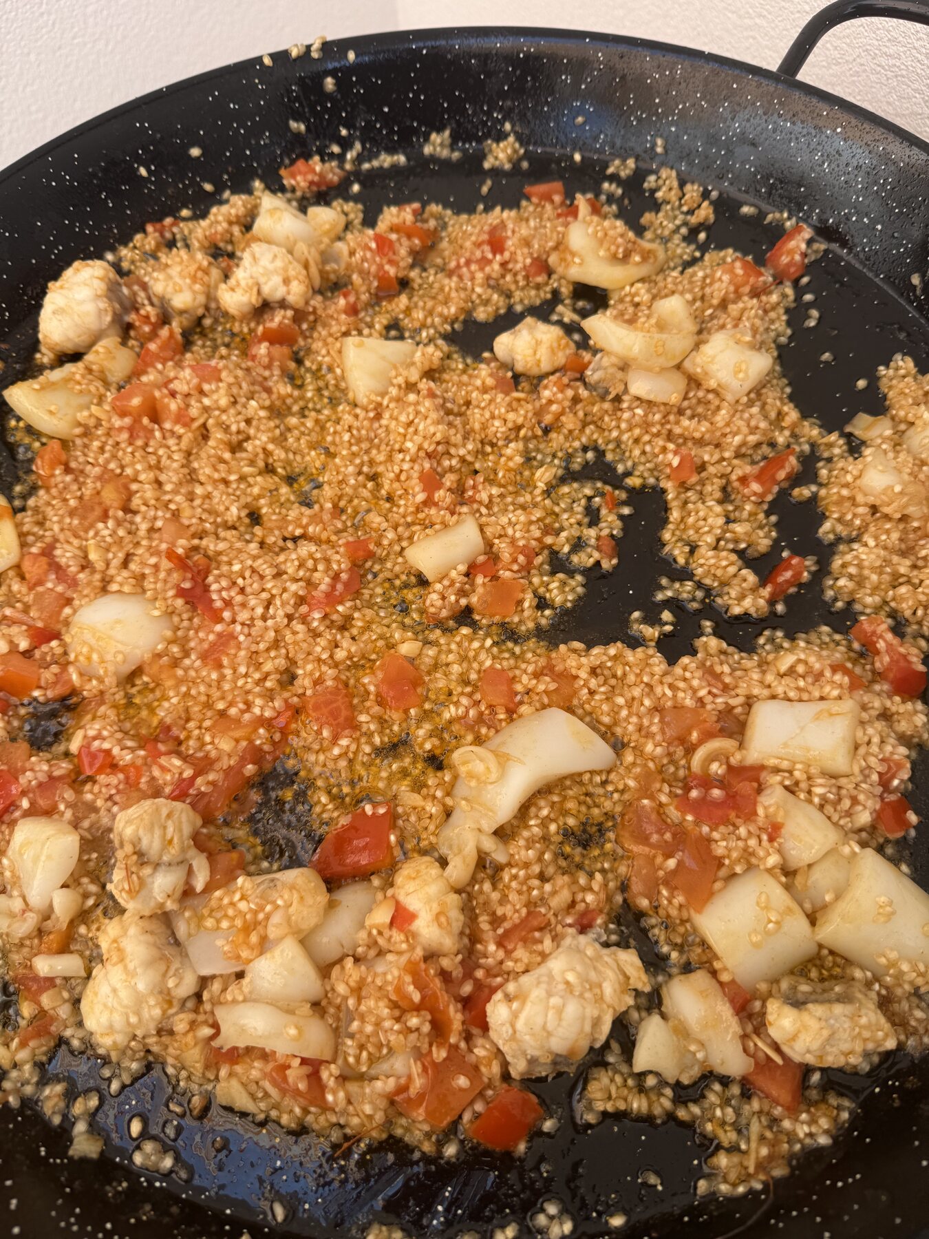 El arroz se añade al sofrito en la paellera